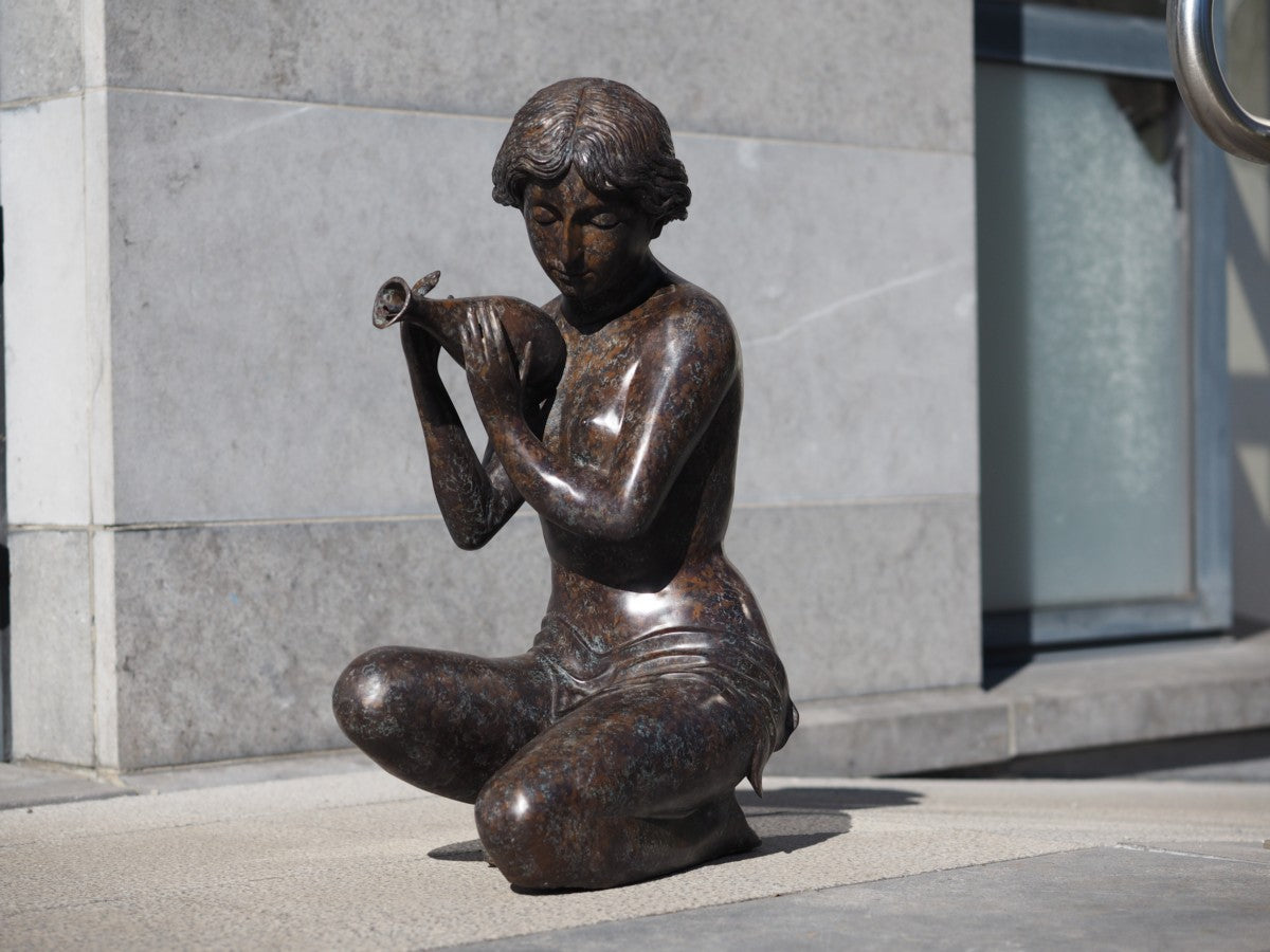 Kneeling woman pouring water (fountain)