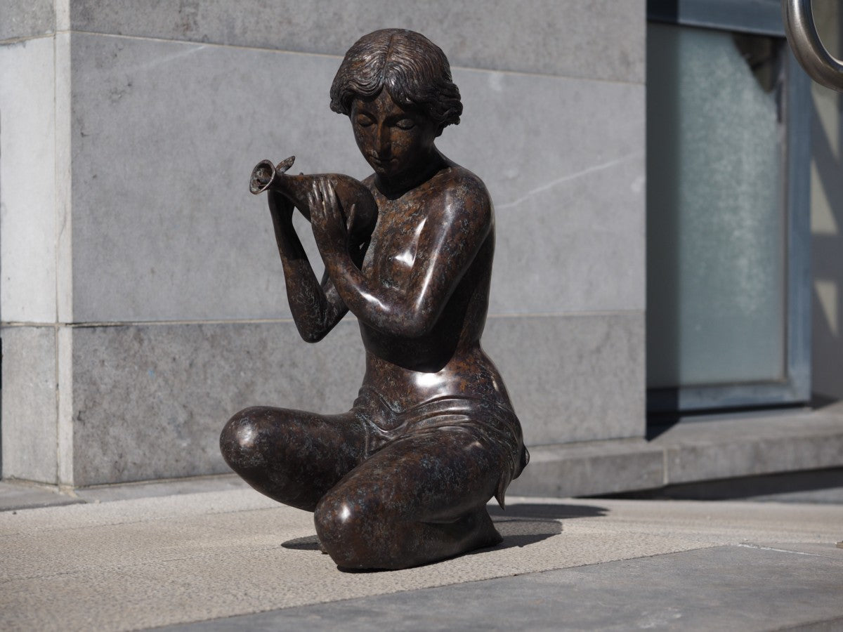 Kneeling woman pouring water (fountain)