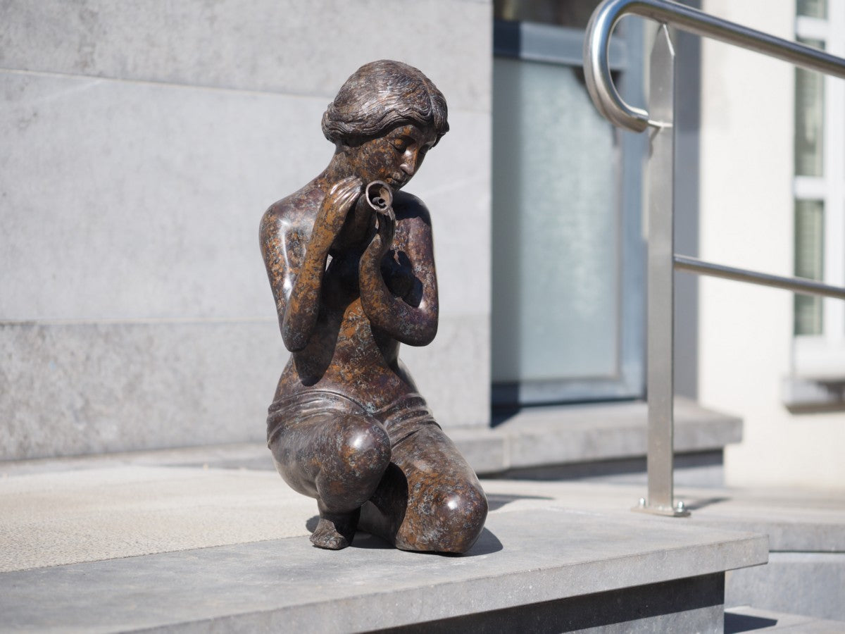 Kneeling woman pouring water (fountain)